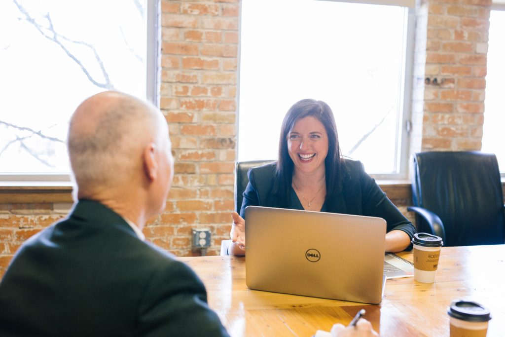 Business people laughing with comuter - realtors selling a house